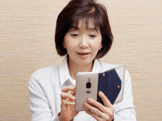 スマートフォンを操作する中年女性